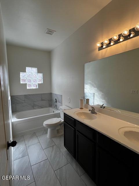 full bathroom with visible vents, double vanity, a sink, toilet, and marble finish floor