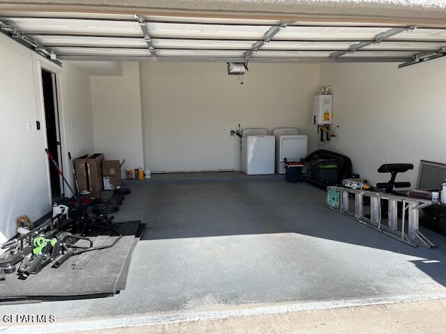 garage with water heater, independent washer and dryer, and a garage door opener