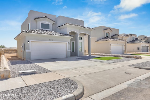 view of front of home with a tiled roof, a garage, concrete driveway, and stucco siding