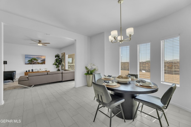 dining room with wood finished floors and ceiling fan with notable chandelier