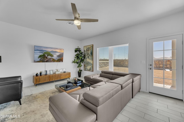 living area featuring visible vents, a wealth of natural light, and ceiling fan