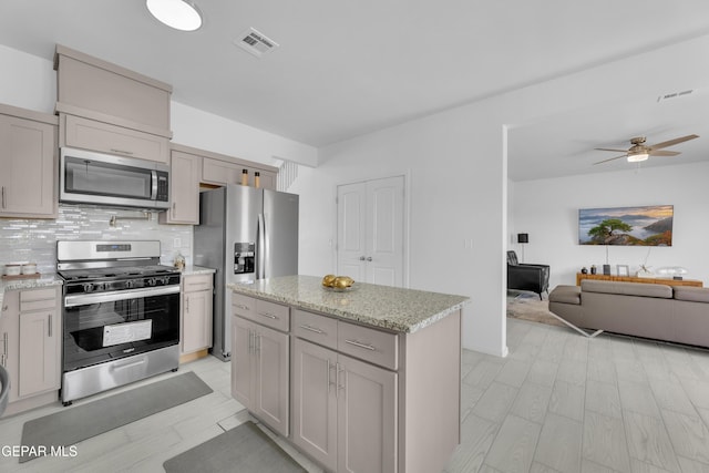 kitchen with open floor plan, visible vents, backsplash, and stainless steel appliances