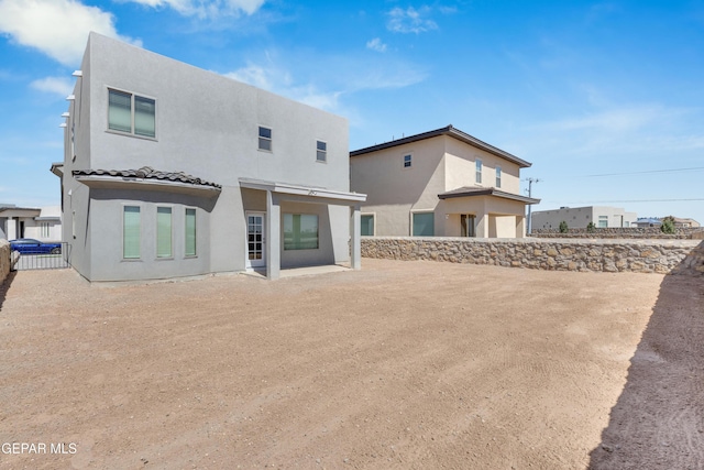 back of property featuring fence and stucco siding