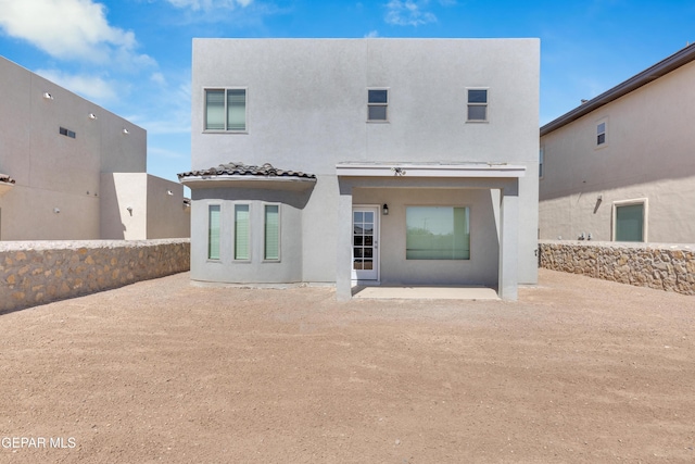 rear view of house with stucco siding and a patio