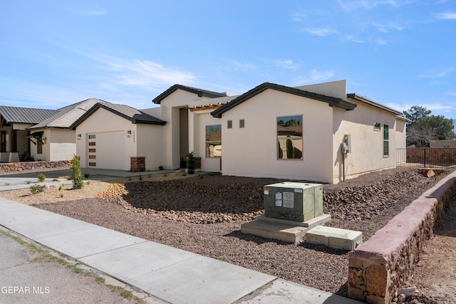 view of front of house with an attached garage, driveway, and stucco siding