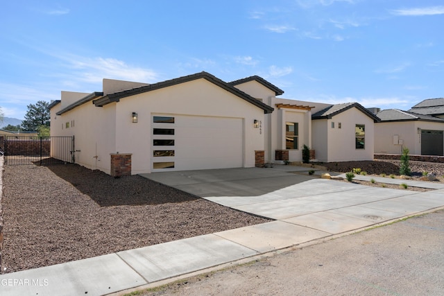 view of front of home with a garage, concrete driveway, and stucco siding