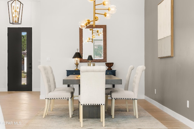 dining area featuring an inviting chandelier, wood finished floors, and baseboards