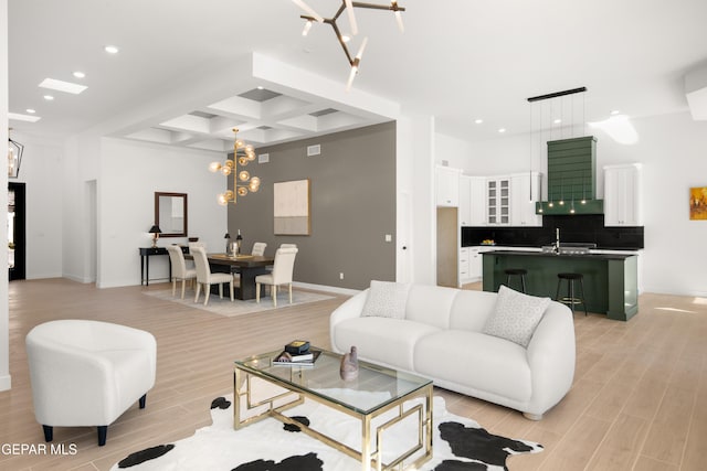 living area with recessed lighting, coffered ceiling, an inviting chandelier, and wood tiled floor