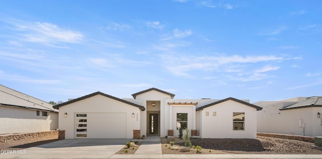 view of front of home featuring a tiled roof, stucco siding, driveway, and a garage