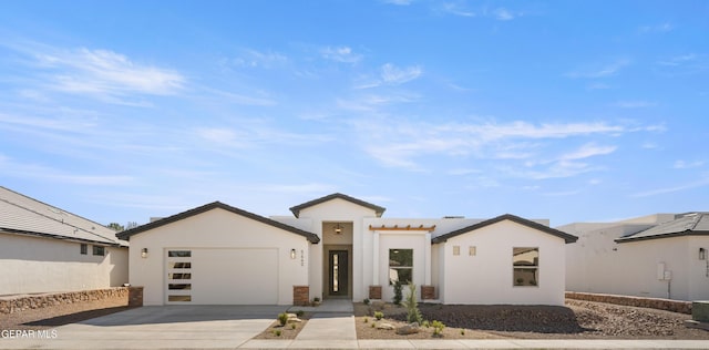 view of front facade featuring a tiled roof, stucco siding, an attached garage, and concrete driveway