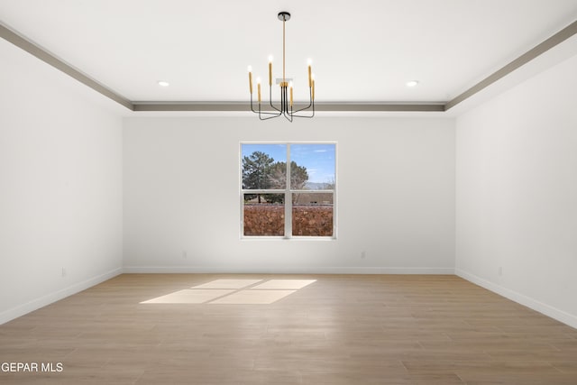 empty room with light wood-type flooring, baseboards, and a chandelier