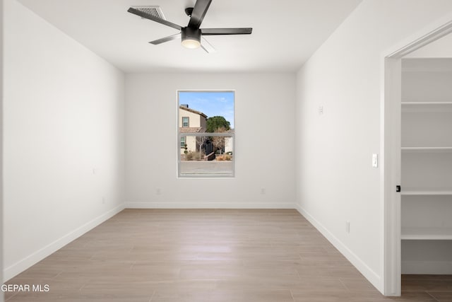 unfurnished room featuring baseboards, light wood-style floors, visible vents, and ceiling fan