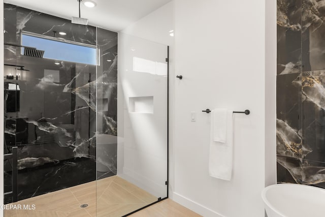 full bathroom featuring a marble finish shower and a freestanding bath