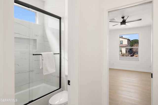 bathroom with a healthy amount of sunlight, toilet, a ceiling fan, and wood finished floors