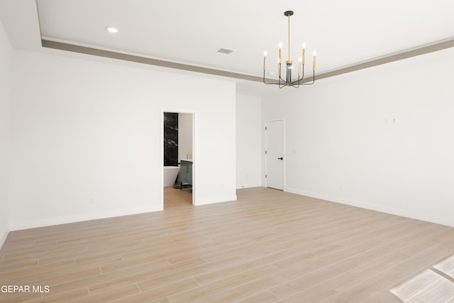 spare room featuring visible vents, a notable chandelier, recessed lighting, light wood-style floors, and baseboards