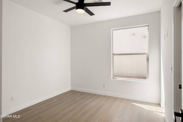 unfurnished room with wood finished floors, a ceiling fan, and baseboards