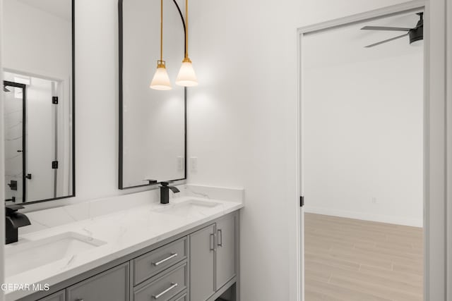 full bath with a sink, wood finished floors, ceiling fan, and double vanity