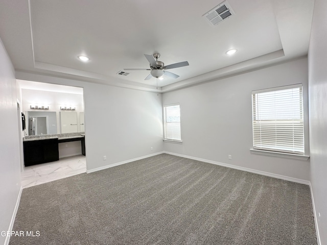 unfurnished room featuring a tray ceiling and visible vents