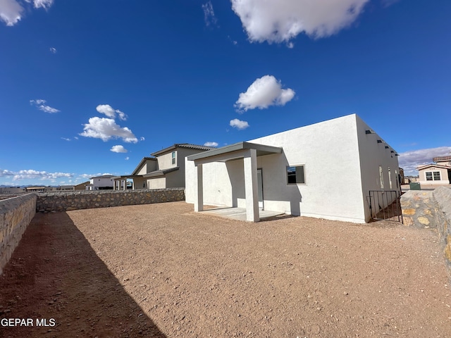 rear view of house with a patio, a fenced backyard, and stucco siding