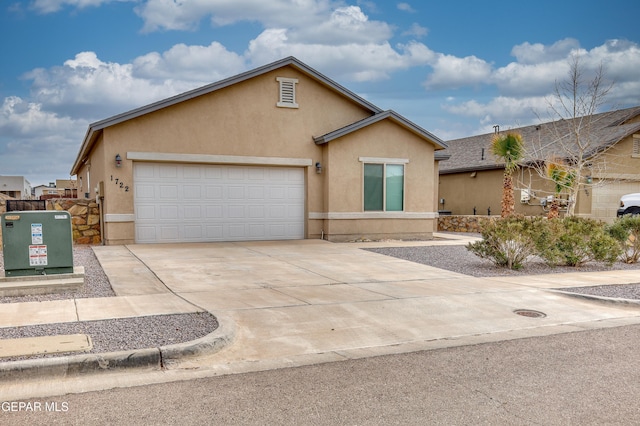 ranch-style house featuring stucco siding, an attached garage, and driveway