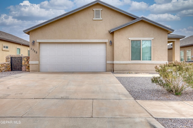 view of front of home with stucco siding, a garage, and concrete driveway