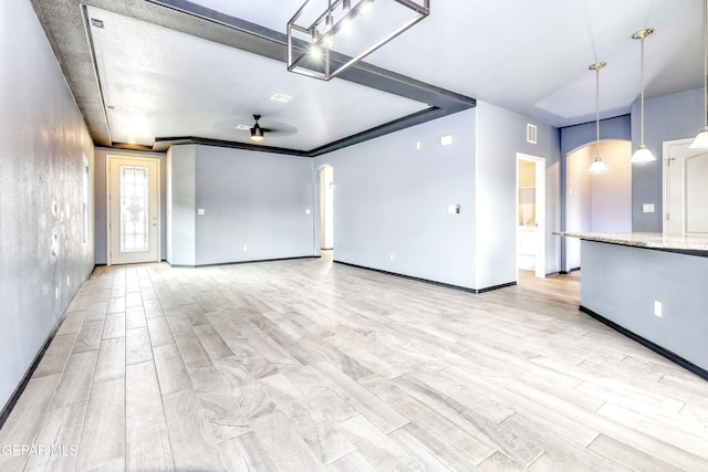 interior space featuring wood finish floors, arched walkways, visible vents, and ceiling fan