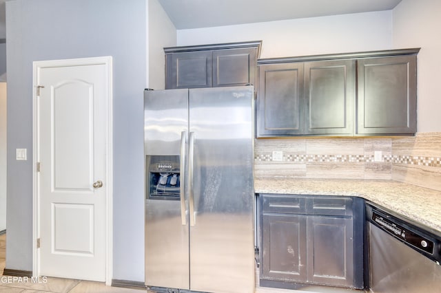 kitchen featuring light stone counters, backsplash, and appliances with stainless steel finishes