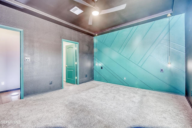 unfurnished bedroom with ensuite bath, visible vents, a ceiling fan, and carpet