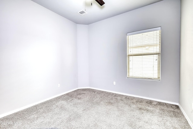 empty room featuring visible vents, baseboards, carpet, and a ceiling fan