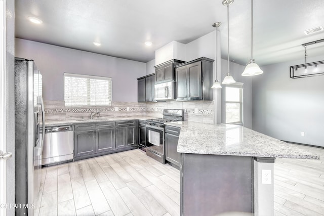 1722 Breeder Cup Way, El Paso, TX 79928 - kitchen with stainless steel appliances, a peninsula, light wood finished floors, light stone counters, and a sink