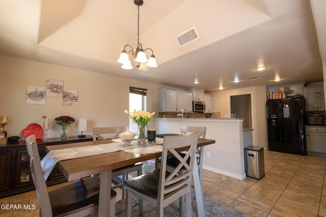 dining area featuring visible vents and an inviting chandelier