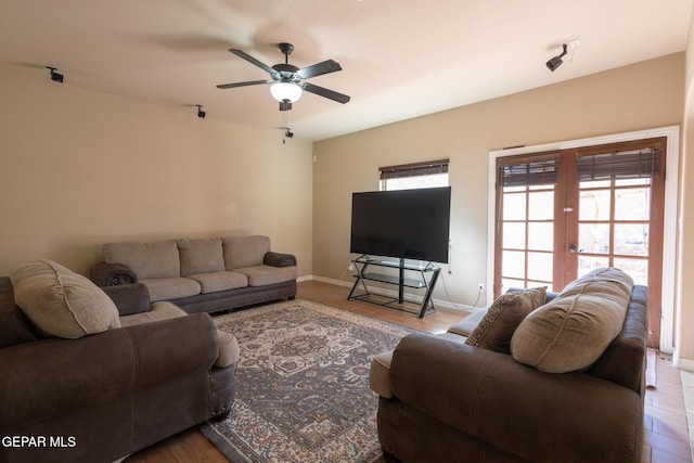 living area with french doors, baseboards, wood finished floors, and a ceiling fan