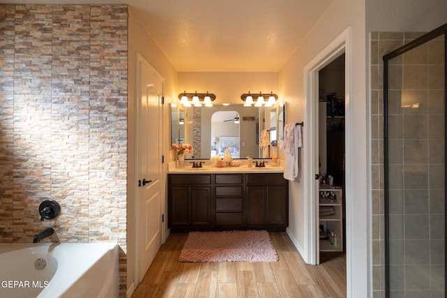 bathroom with a sink, a stall shower, wood tiled floor, and a bath