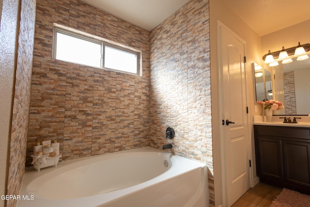 full bathroom featuring a washtub and vanity