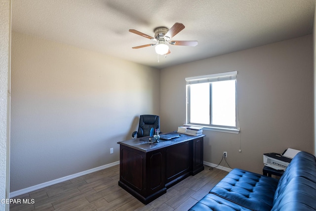 office area with baseboards, a textured ceiling, ceiling fan, and light wood finished floors