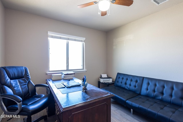 office space with wood finished floors, visible vents, and ceiling fan