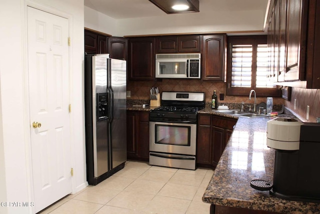 kitchen with light tile patterned floors, a sink, stainless steel appliances, dark brown cabinets, and backsplash