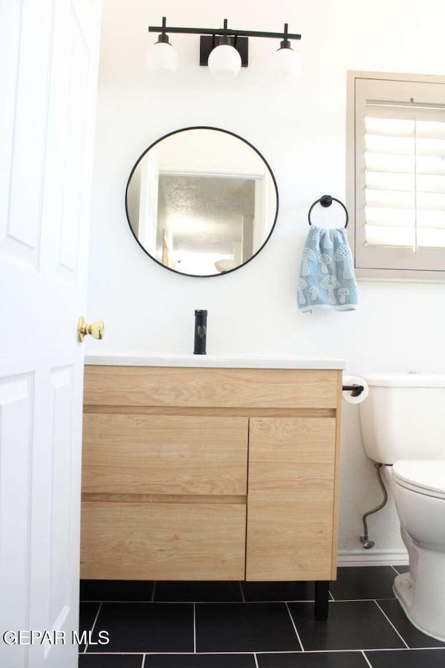 bathroom featuring tile patterned floors, toilet, vanity, and baseboards