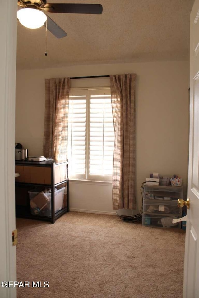 bedroom featuring ceiling fan, a textured ceiling, and carpet