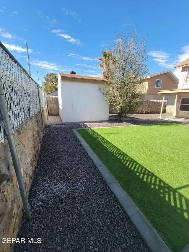 view of yard featuring an outdoor structure and fence