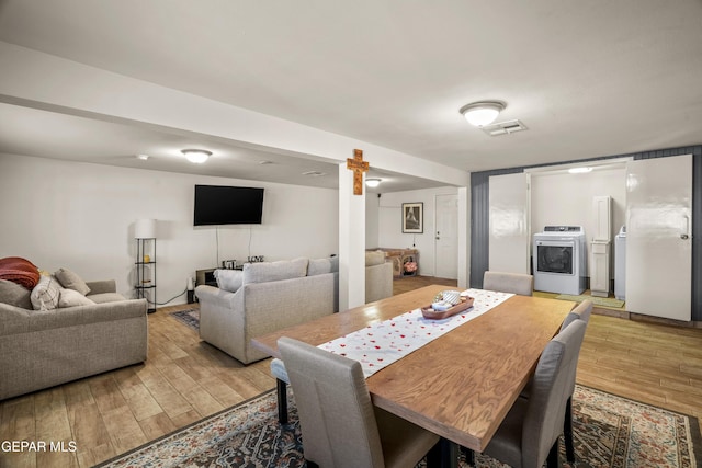 dining room featuring visible vents, washer / dryer, and light wood-style flooring