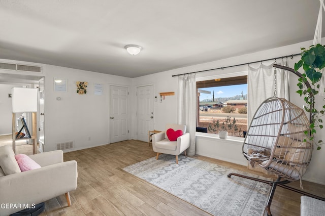 sitting room featuring visible vents, baseboards, and wood finished floors