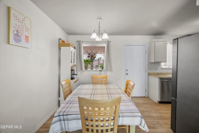 dining area with a notable chandelier and light wood-type flooring