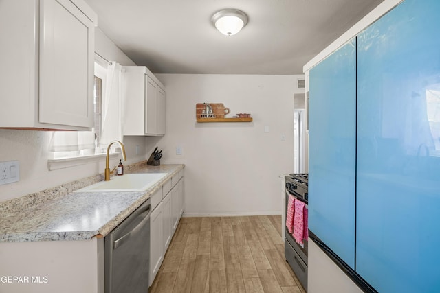 kitchen with a sink, stainless steel dishwasher, gas stove, white cabinets, and light wood finished floors