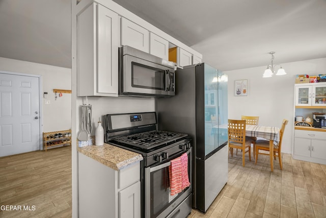 kitchen featuring a chandelier, light wood-type flooring, stainless steel appliances, and light countertops