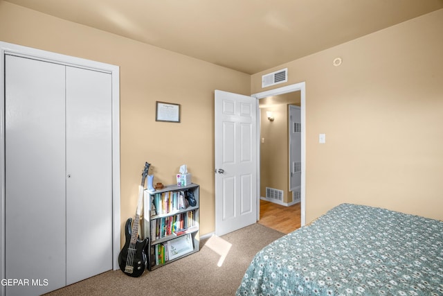 carpeted bedroom featuring a closet and visible vents