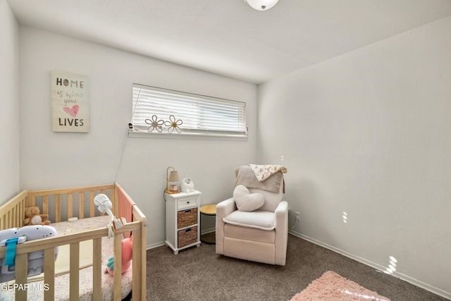 bedroom featuring baseboards, a crib, and carpet