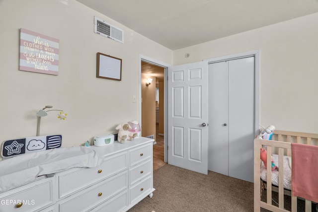 carpeted bedroom featuring visible vents and a closet