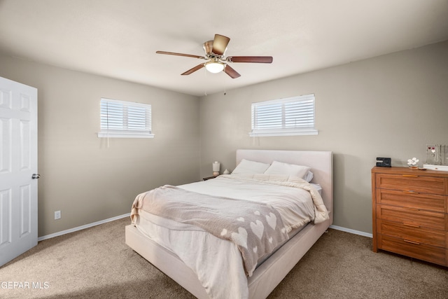 carpeted bedroom with multiple windows, baseboards, and ceiling fan