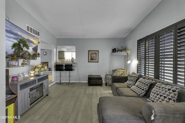 living area with visible vents, baseboards, and wood finished floors